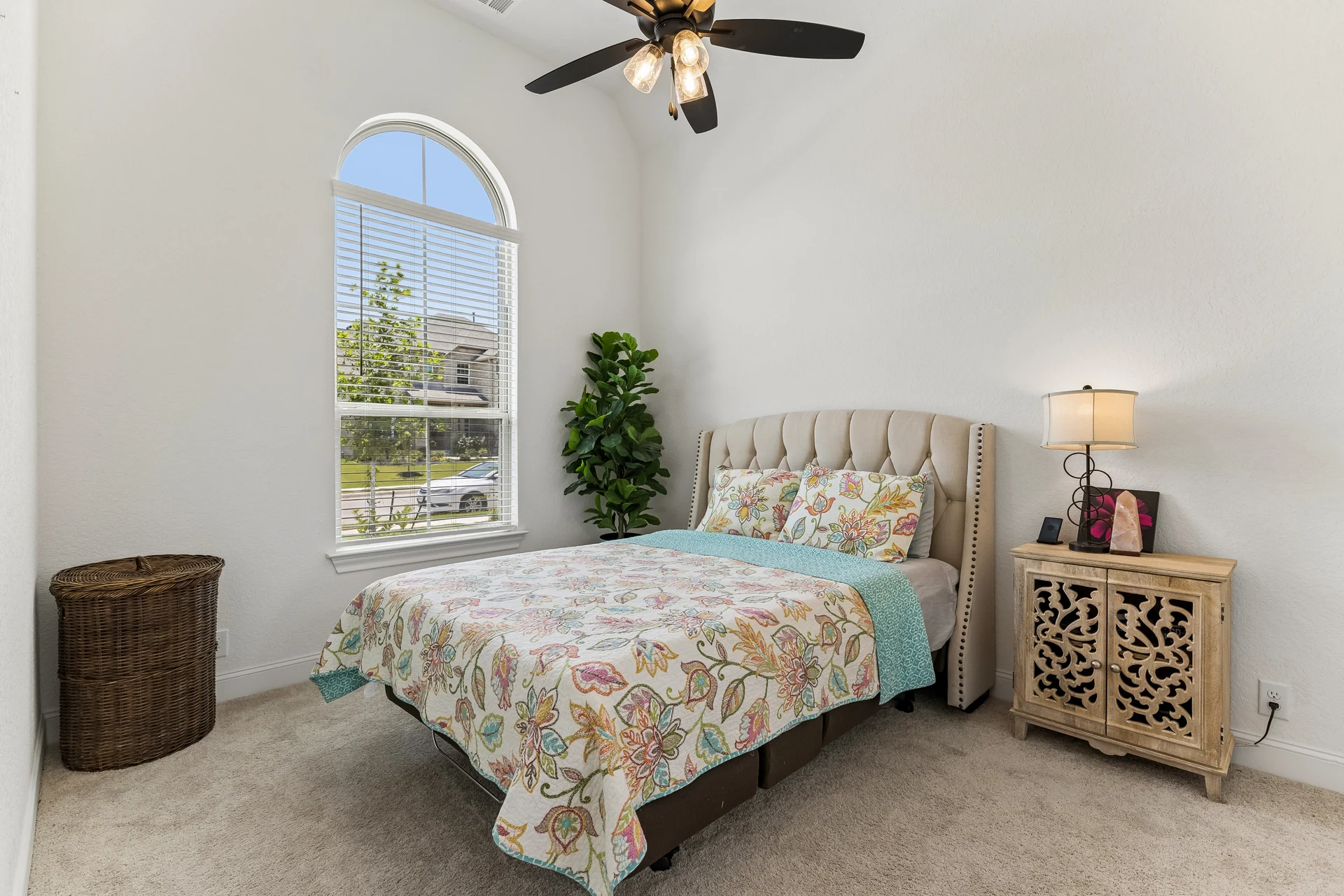 Furnished guest bedroom with an arched window