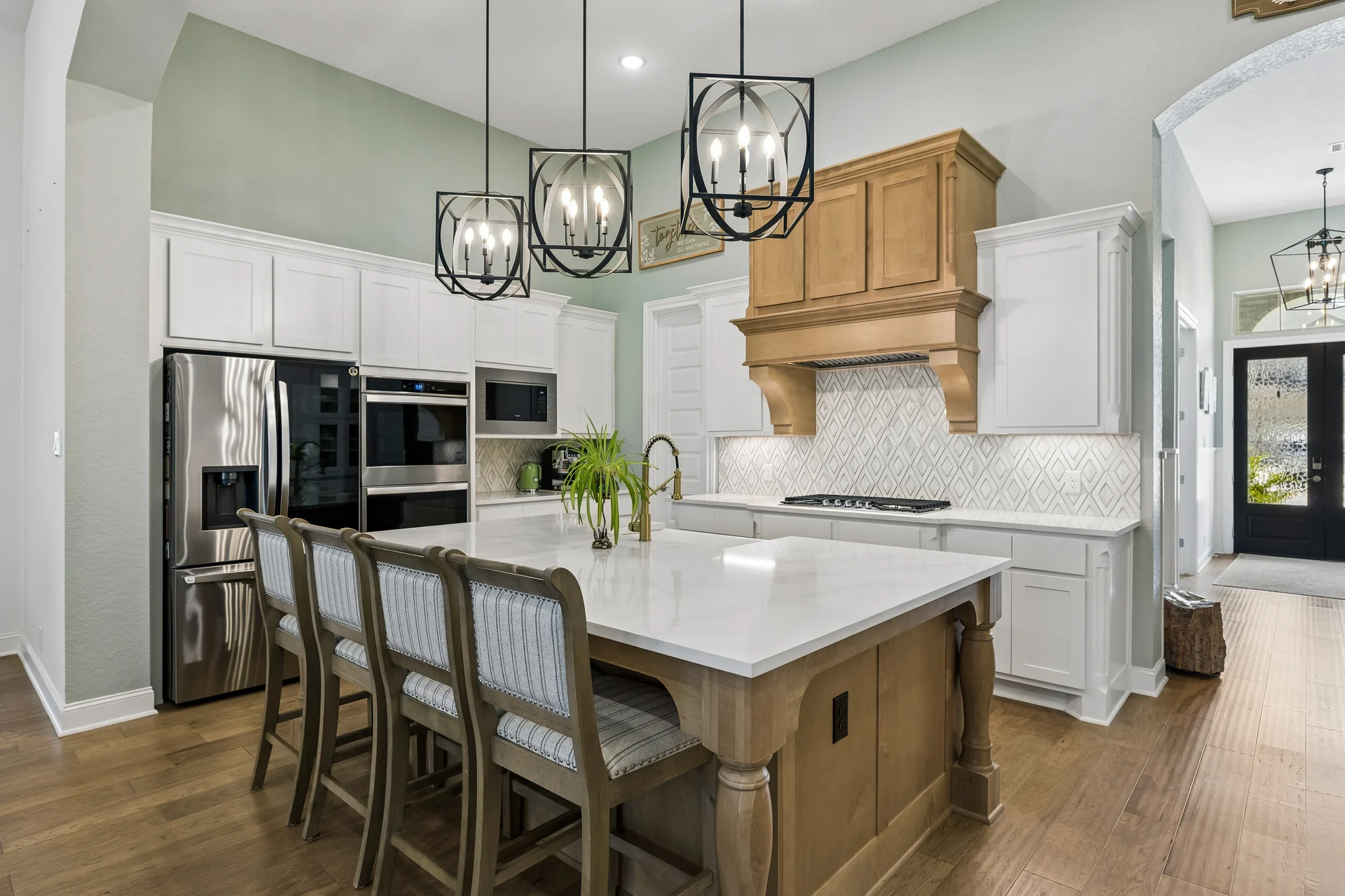 Wood island and range hood against white kitchen cabinetry