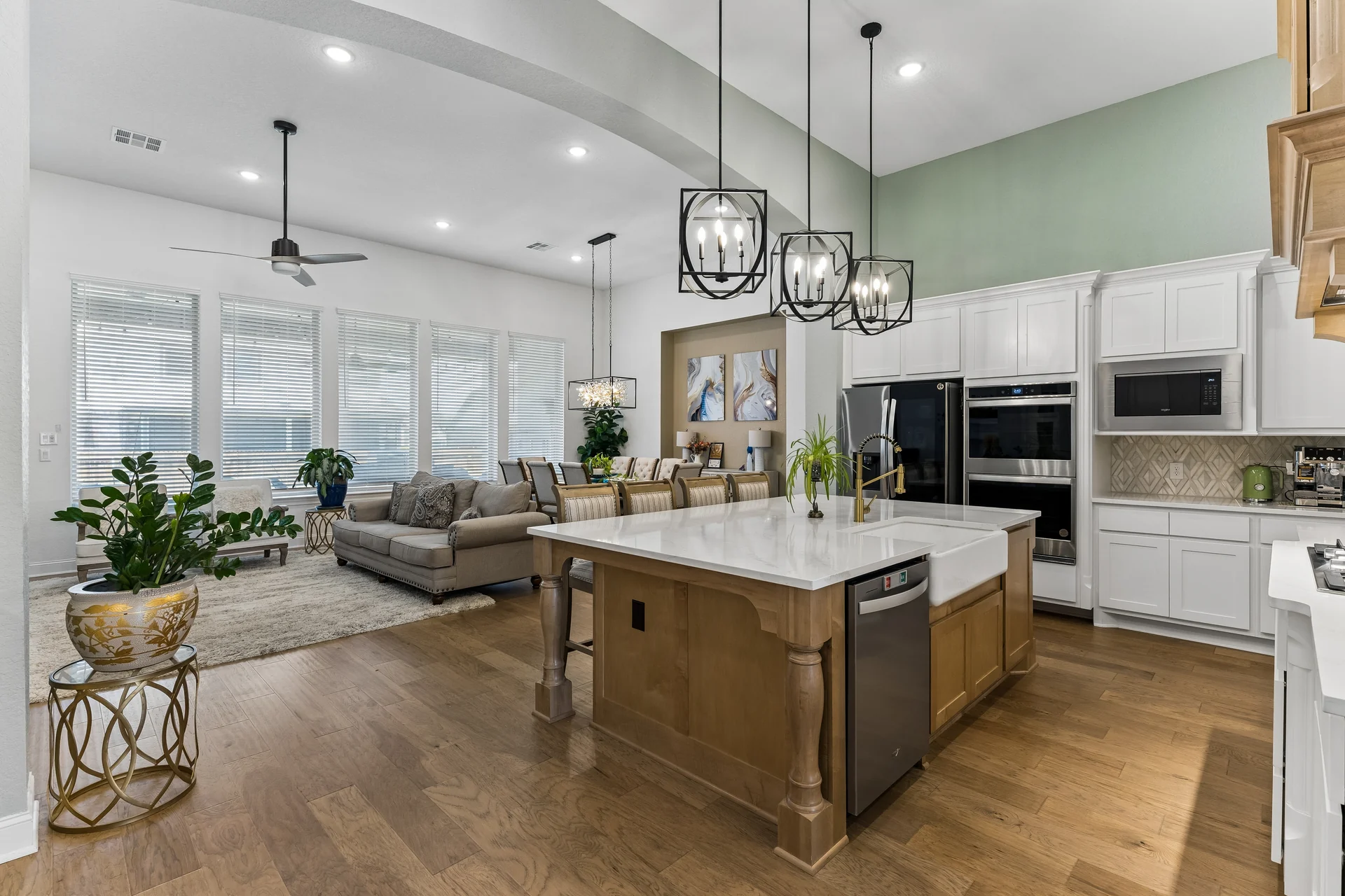Island kitchen opening to the furnished living and dining spaces