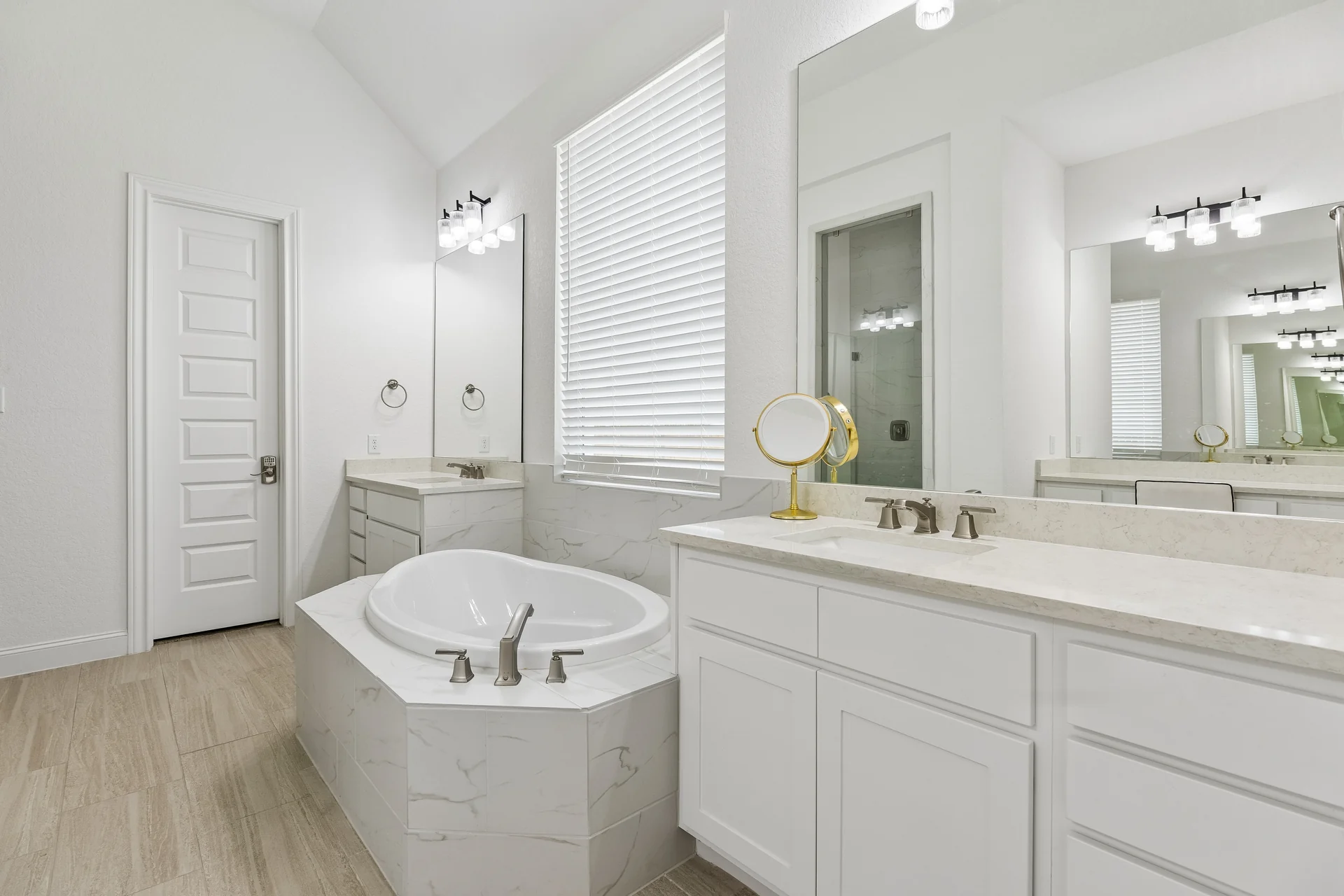 White primary bathroom with soaking tub and separate vanities