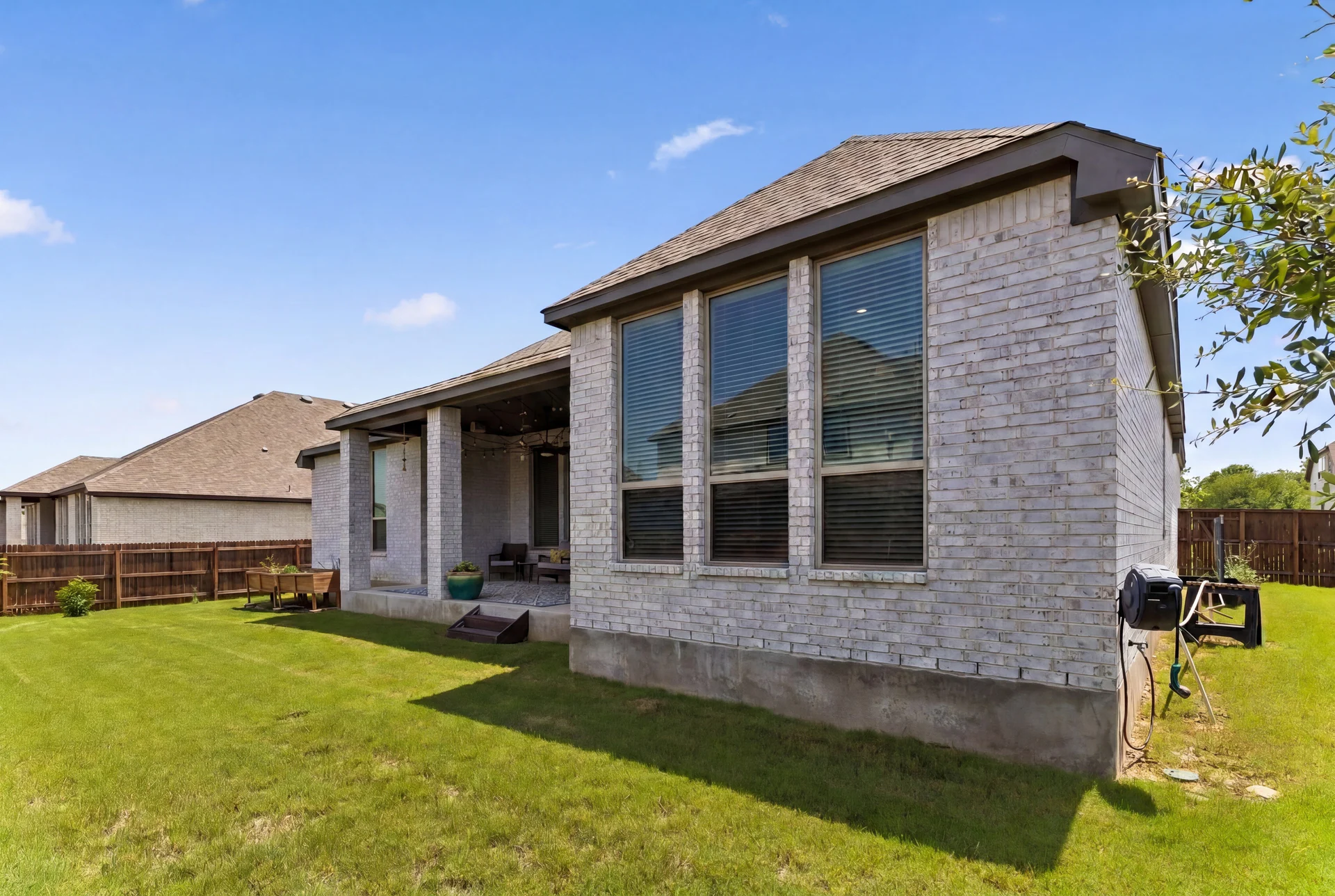 Rear white-brick elevation, lawn and covered patio