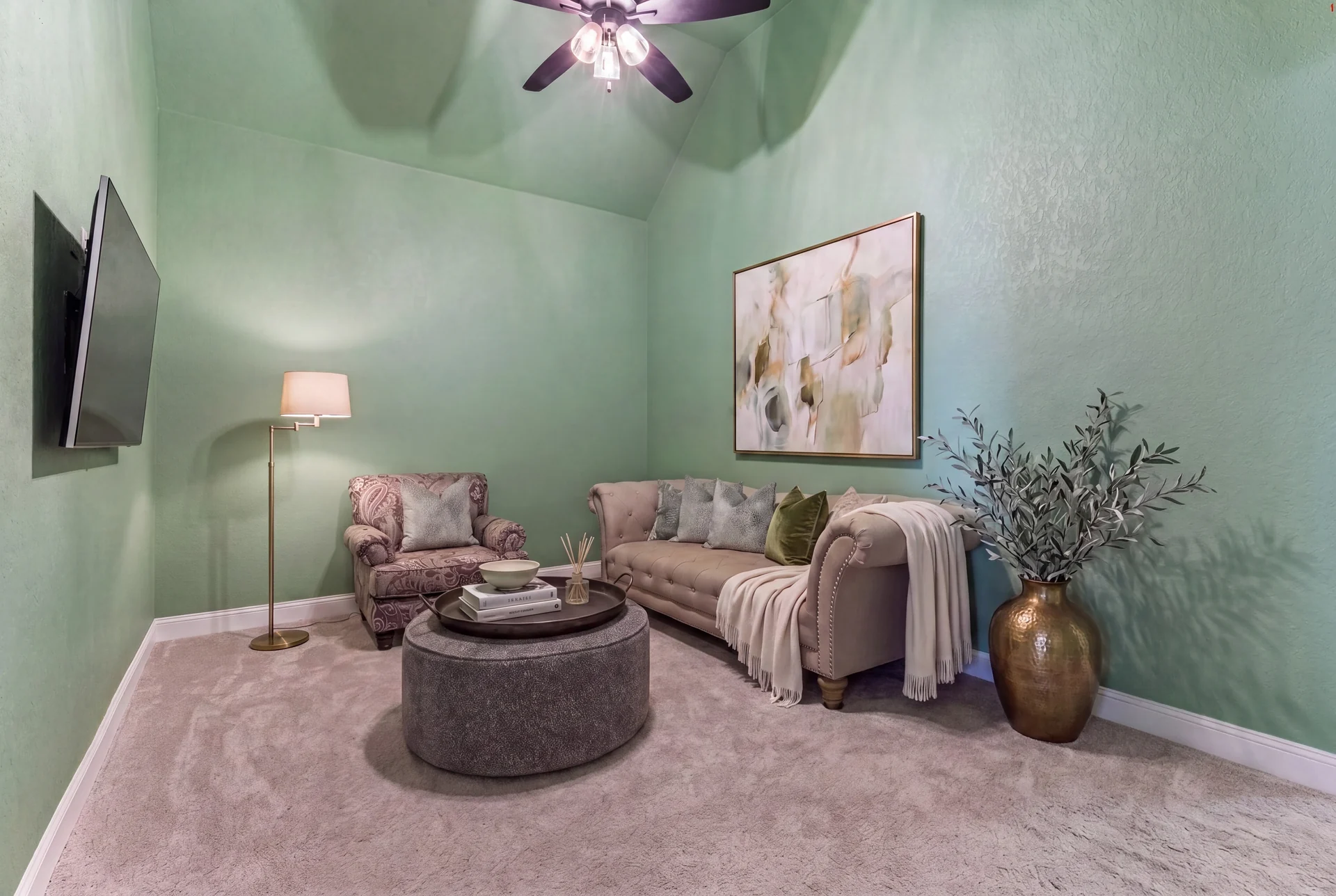 Second living room with sage walls, sofa and armchair